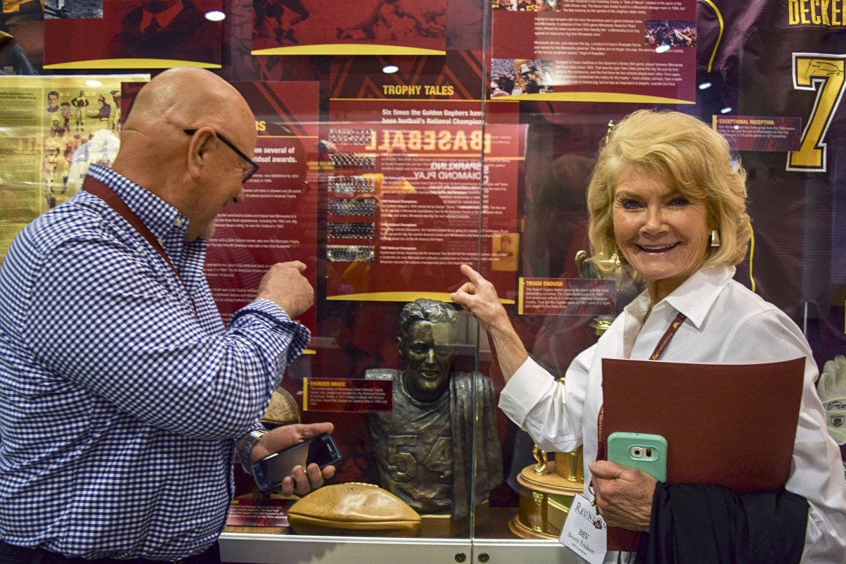 A couple pointing at a historic photo in a display case.