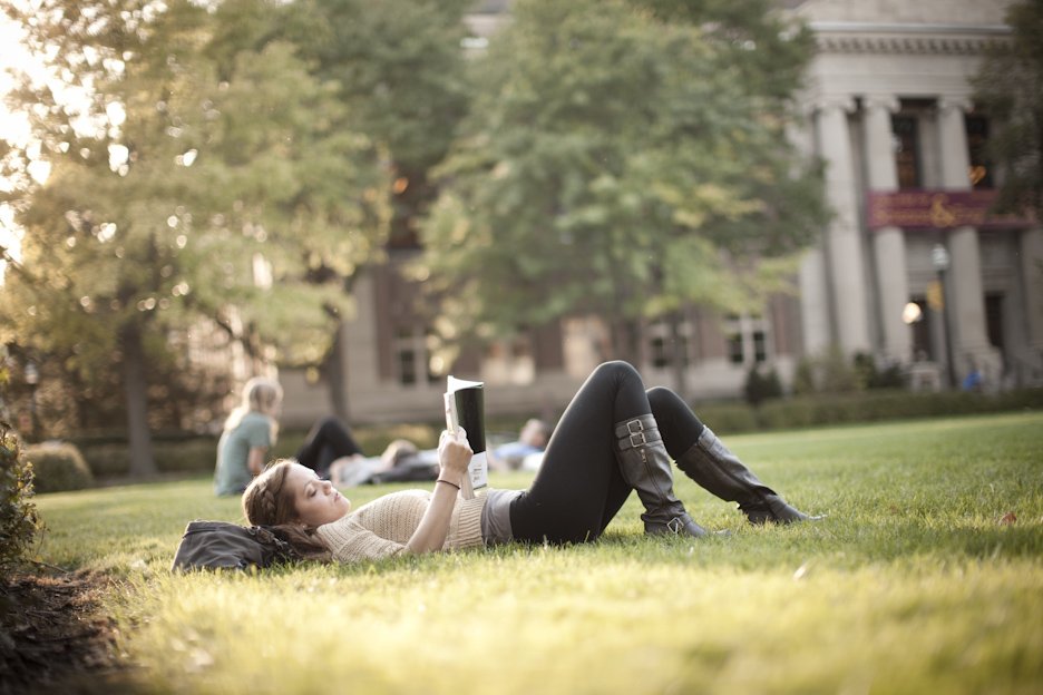 student reading outside on campus mall